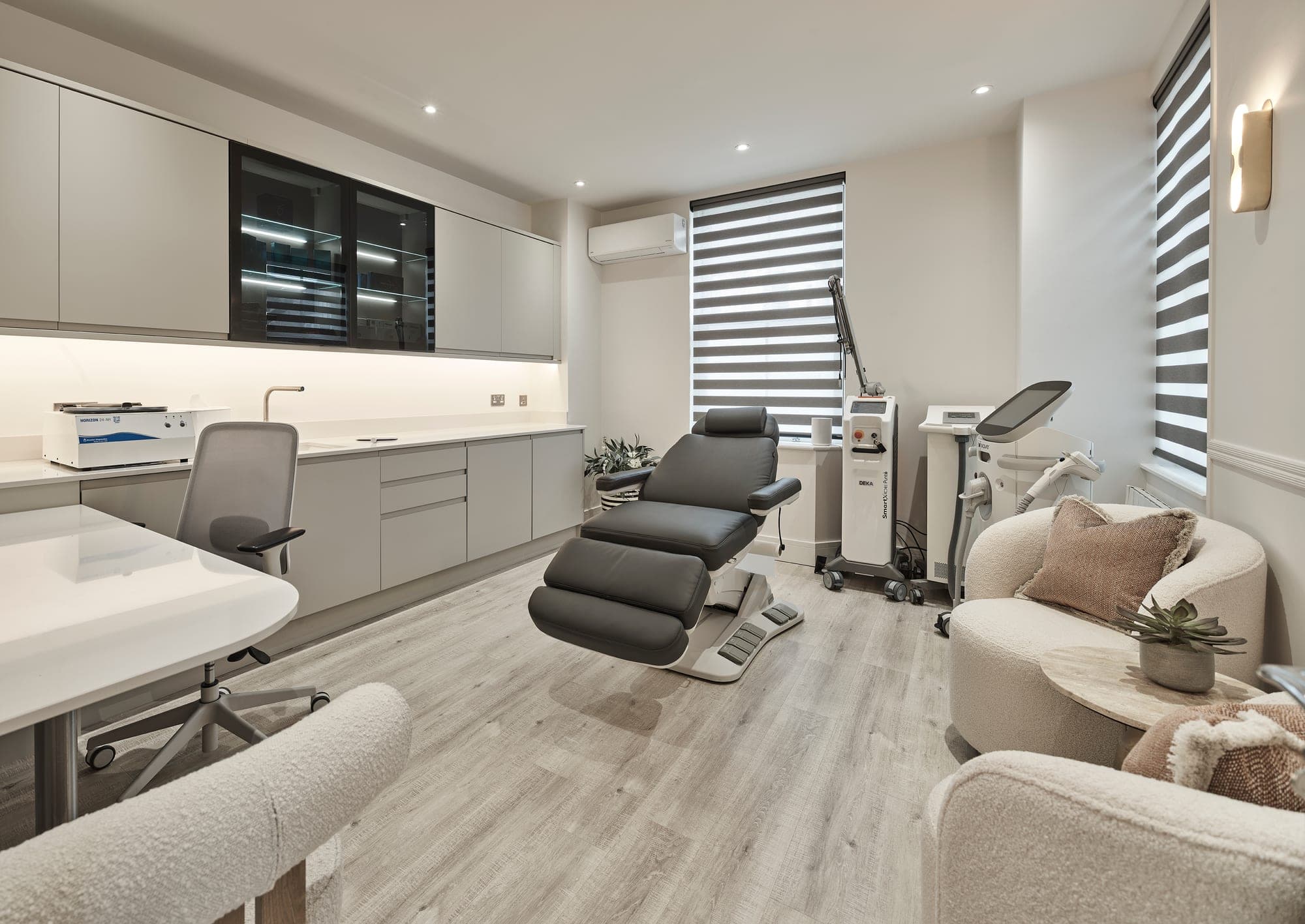 Treatment room with a treatment chair and lounge seating, Bank Medi Spa, Hale
