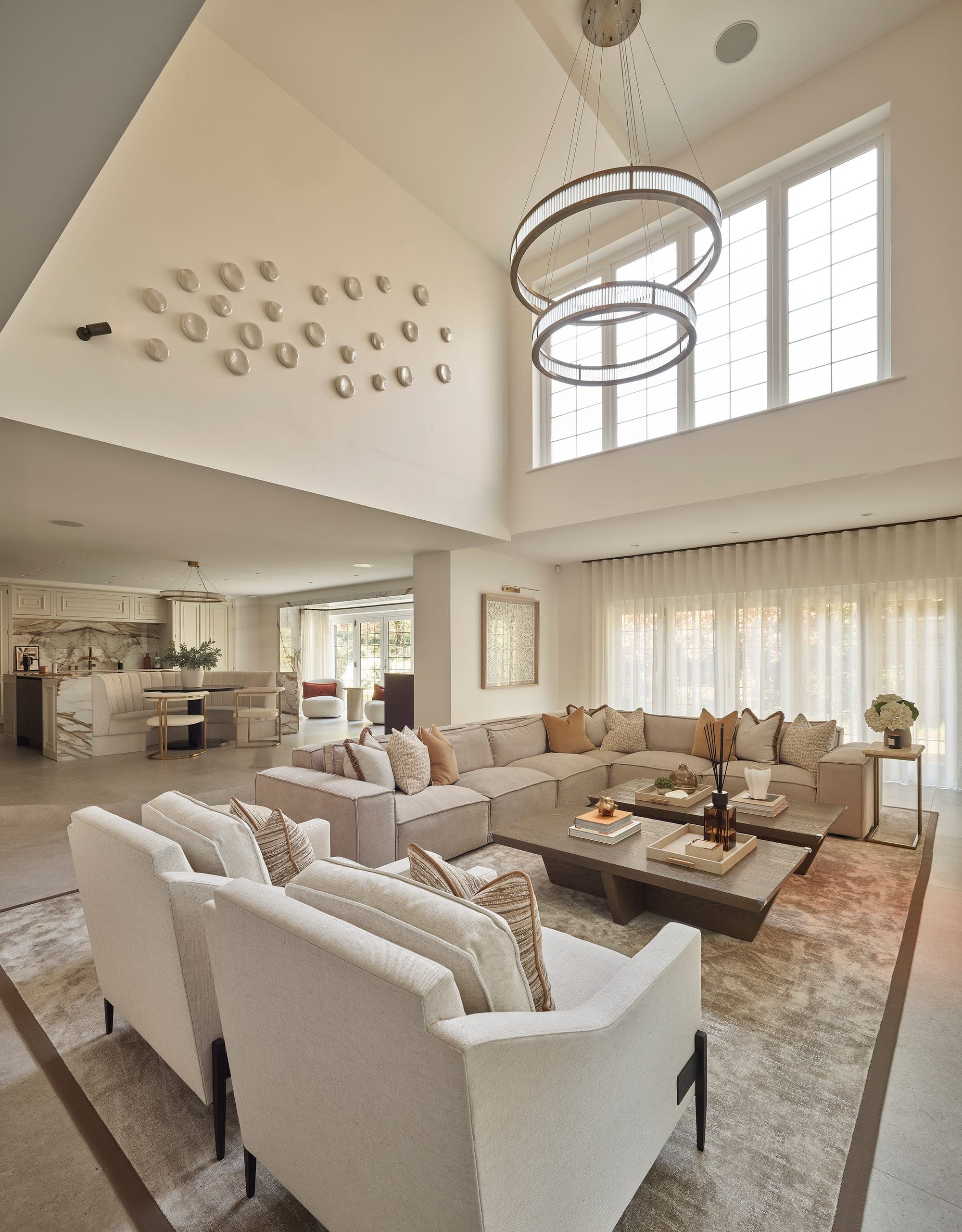 Double-height open-plan living and kitchen space with sheer curtains, Prestbury family home, Cheshire