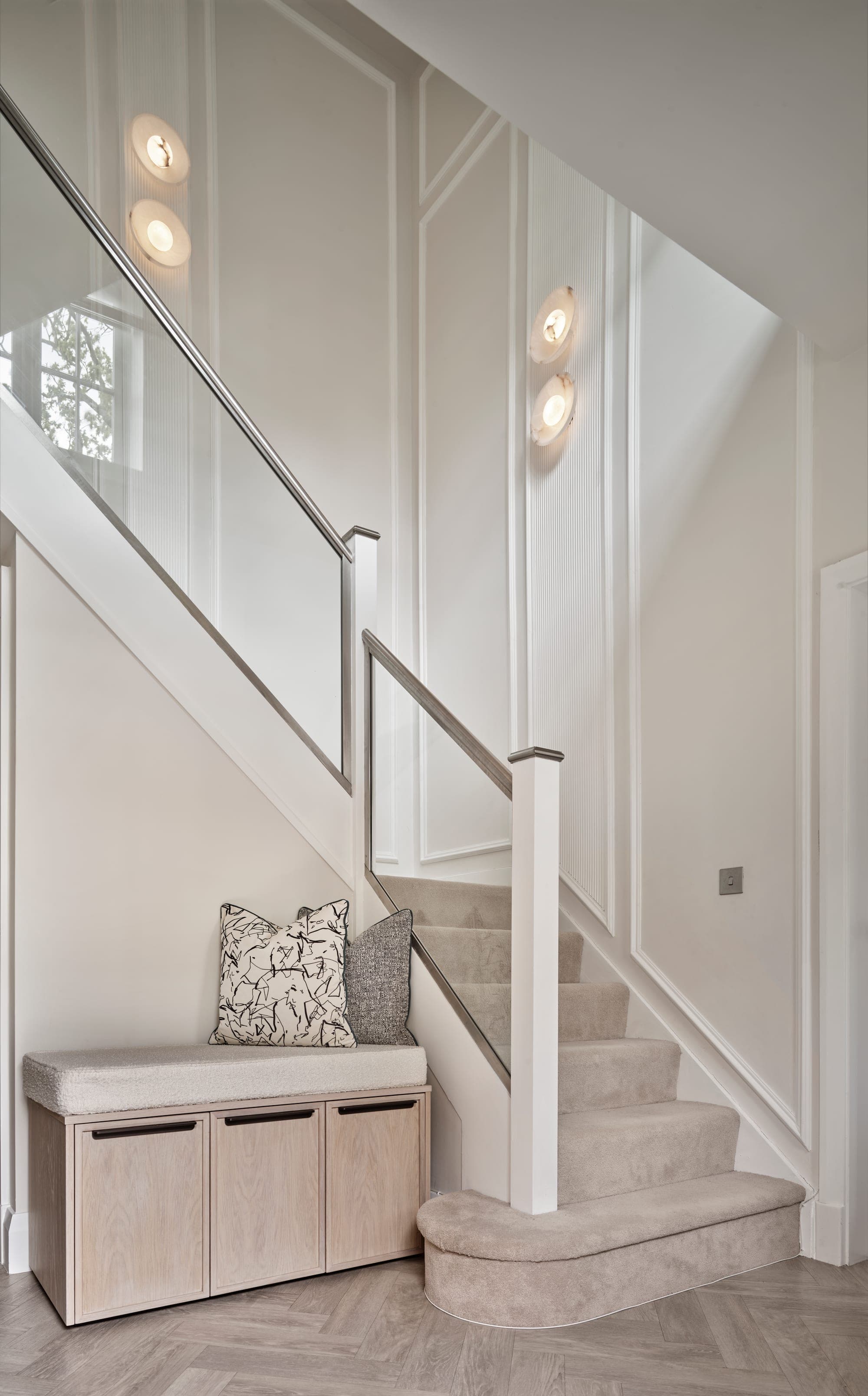 Staircase with a glass balustrade and panelled walls above a bespoke oak window seat with storage, Adlington Road, Wilmslow